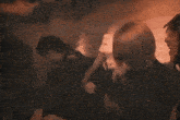 a group of people are sitting around a table in a dark room .