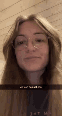 a woman wearing glasses and a shirt that says " je tous deja dit non " on it