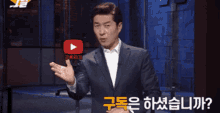 a man in a suit is standing in front of a youtube play button