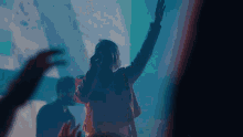 a woman singing into a microphone while a crowd watches