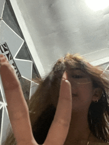 a woman making a peace sign in front of a sign that says 21