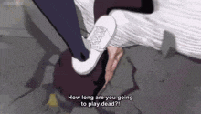 a person is laying on the ground with their head on the ground and a person is kicking them .