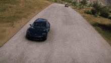 a blue car is driving down a road with a yellow car behind it