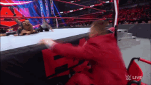 a man in a red suit is sitting in a wheelchair in front of a sign that says w live