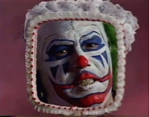 Person in clown makeup looking in mirror