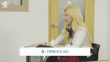 a girl with blonde hair is sitting at a desk in a classroom with a flower in her hair