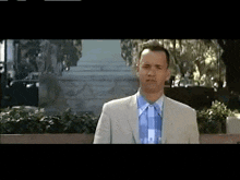 a man in a suit and tie is standing in front of a building