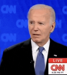 a man in a suit and tie with a cnn live sign