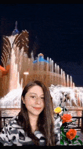 a woman stands in front of a fountain with a building in the background that has the word casino on it