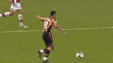 a soccer player jumps to catch a ball in front of a emirates sign