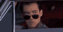 a man wearing sunglasses is sitting in a car .