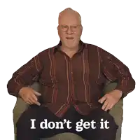 a man in a striped shirt sits in a chair with the words i don 't get it written below him