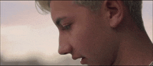 a close up of a young man 's face with a blurred background