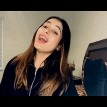 a woman is making a funny face while wearing headphones .