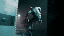 a man in a black jacket is jumping in the air in a dark room