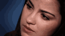 a close up of a woman 's face with a tear running down her face .