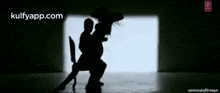a silhouette of a man sitting on a woman 's lap with the website kulfyapp.com at the bottom
