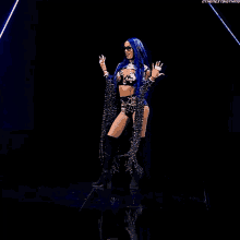 a woman with blue hair is standing on a stage in front of a black background with the hashtag #thenextbigthing
