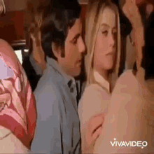 a man is touching a woman 's breast on a bus while a woman looks on .
