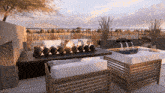 a patio with a fire pit and chairs and a waterfall
