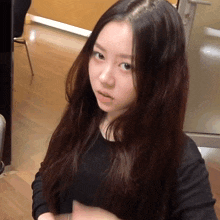 a woman with long dark hair looks at the camera