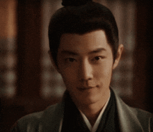 a close up of a man 's face with a bun on his head