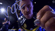 a man in a black shirt is writing the word cop on a glass surface