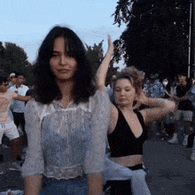 a woman in a white top is standing next to another woman in a black top