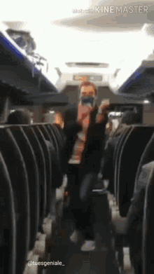 a man is dancing on an airplane while wearing a face mask .