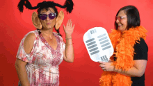 a woman wearing fake ears and sunglasses holds a microphone prop