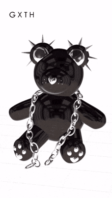 a black teddy bear with chains around its neck and spikes on its head