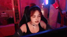 a woman wearing headphones and a microphone is sitting in front of a computer monitor .