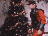 a man wearing a hat and a red jacket is making a funny face .