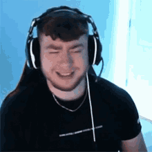 a man with a beard is wearing headphones and smiling while playing a video game .