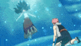 a man is kneeling down in front of a mermaid floating in the water