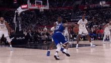 a basketball player with the number 13 on his back is dribbling the ball .