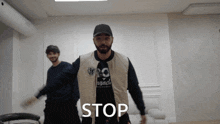 a man with a beard wearing a jacket that says stop on it