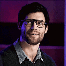 a man with a beard wearing glasses and a sweater