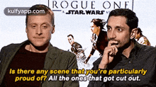 two men are sitting in front of a poster for rogue one star wars .