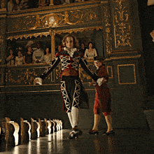 a man in a costume stands in front of a crowd of people