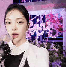 a woman stands in front of a sign that says ' love '