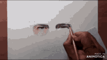 a person is drawing a man 's eyes with a pencil .
