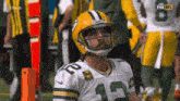 a green bay packers football player wearing a yellow helmet