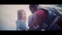 a man and a little girl are standing next to each other and looking at each other .