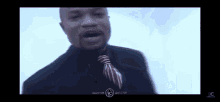 a man in a suit and tie is singing in a video