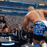 a wrestler in a stadium with a banner that says bathroom wipes on it