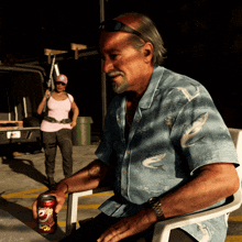 a man sits in a chair with a can of dr pepper in front of him