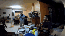 a man playing a guitar in front of a table with food