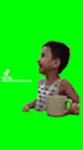 a young boy is sitting next to a cup of coffee on a green screen .