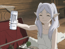 a girl is holding a can of monster ultra